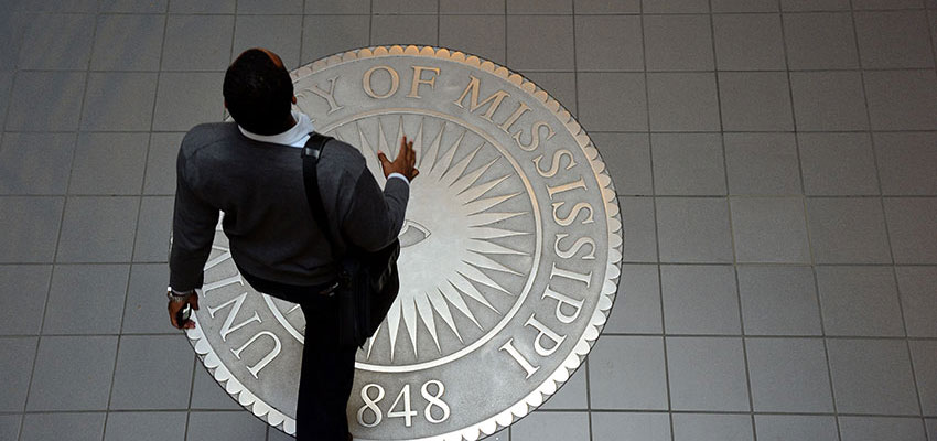 Student walking over the university seal in Martindale Hall